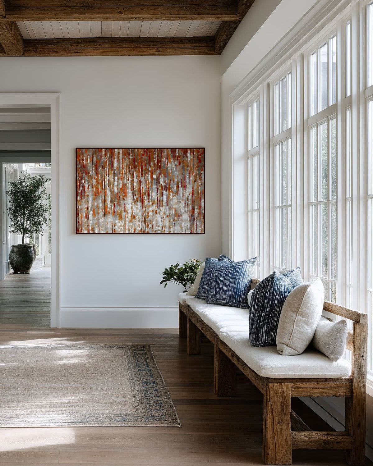 Under His Care, Isaiah 54:17 canvas print above a cushioned bench beside a wall of windows